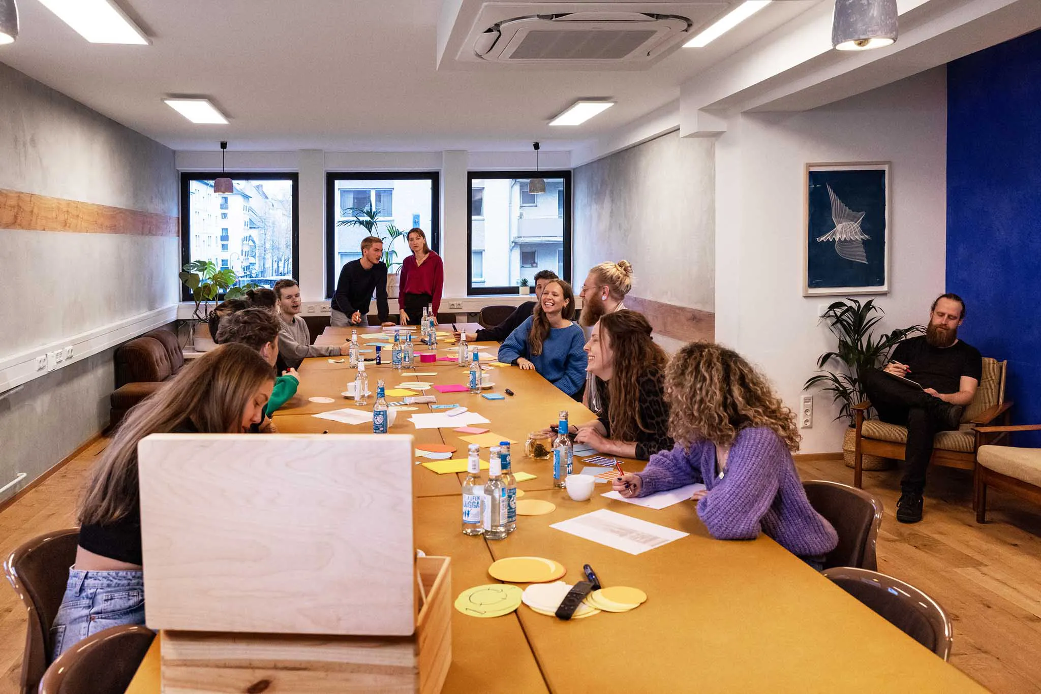 Viele Menschen sitzen an einem großen Tisch und arbeiten zusammen